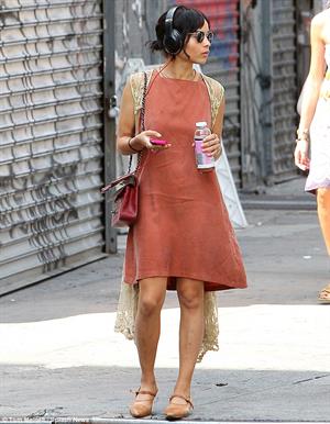 Zoe Kravitz walking in shorts and an orange top