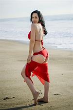 Nadya Suleman is better known as Octomom.  She was born Natalie Denise Suleman on July 11, 1975.  After 14 children she is stripping and making porn...  Here she is on a beach in a red bikini