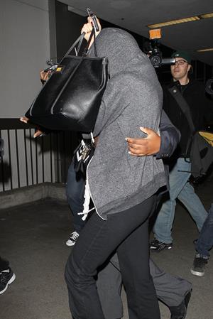 Selena Gomez departing out of LA, hiding her face