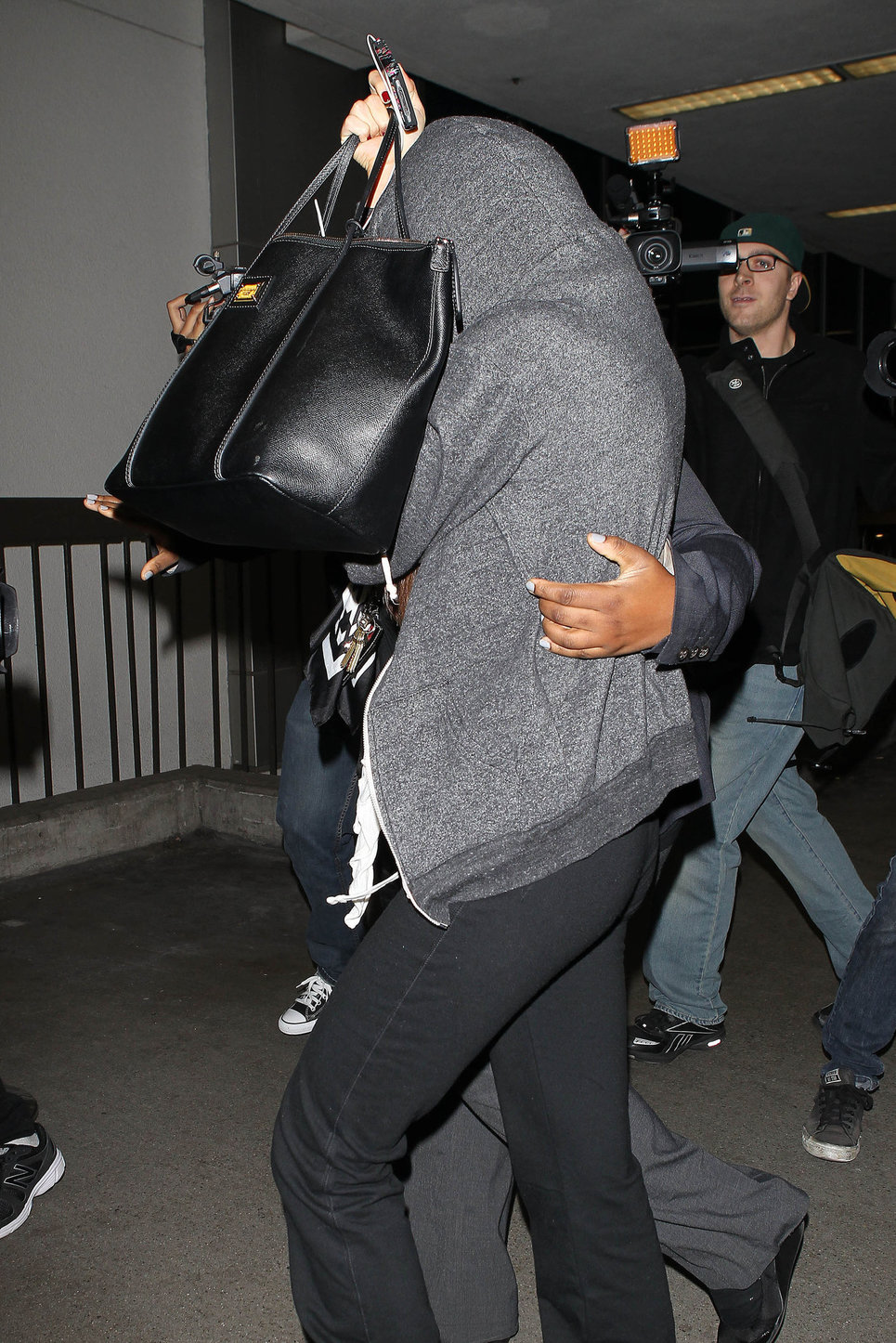 Selena Gomez departing out of LA, hiding her face