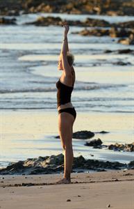 Miley Cyrus  yoga in black bikini on beach in Hawaii 1/24/13 