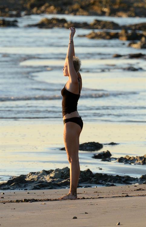 Miley Cyrus  yoga in black bikini on beach in Hawaii 1/24/13 