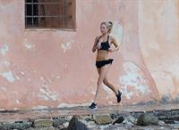 Kimberley Garner in a black bikini on the beach in St. Tropez on July 31, 2014