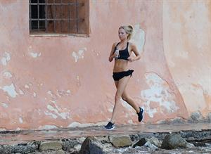 Kimberley Garner in a black bikini on the beach in St. Tropez on July 31, 2014