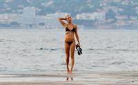 Kimberley Garner in a black bikini on the beach in St. Tropez on July 31, 2014