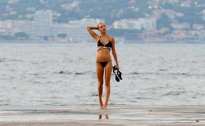 Kimberley Garner in a black bikini on the beach in St. Tropez on July 31, 2014