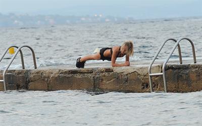 Kimberley Garner in a black bikini on the beach in St. Tropez on July 31, 2014