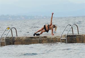 Kimberley Garner in a black bikini on the beach in St. Tropez on July 31, 2014