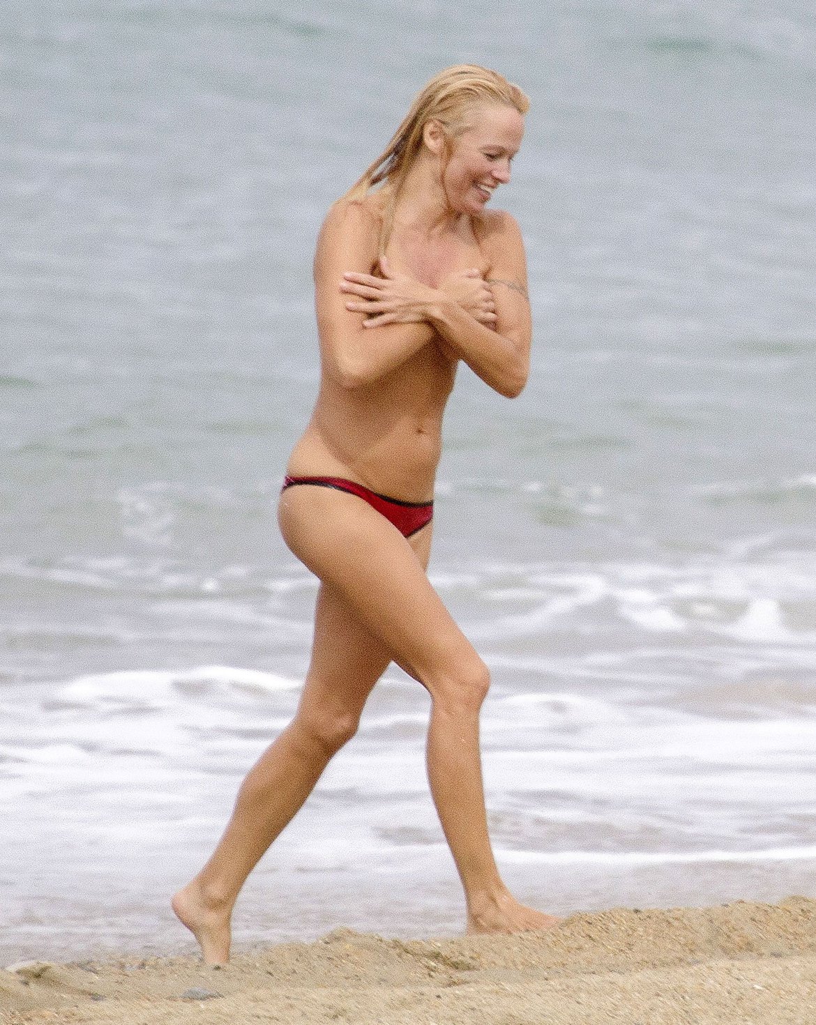 Pamela Anderson Pamela Anderson Going topless at the beach in France 02.10.13