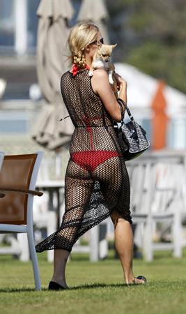 Paris Hilton at the beach in a skimpy red bikini and fishnet kaftan in Malibu.July 12, 2013