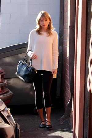 Taylor Swift wearing a white top and black pants in Los Angeles 10/28/13  