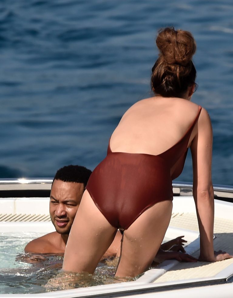Chrissy Teigen Bikini Pictures Chrissy Teigen sexy cleavage and ass in a swimsuit with her husband John Legend seen by paparazzi.