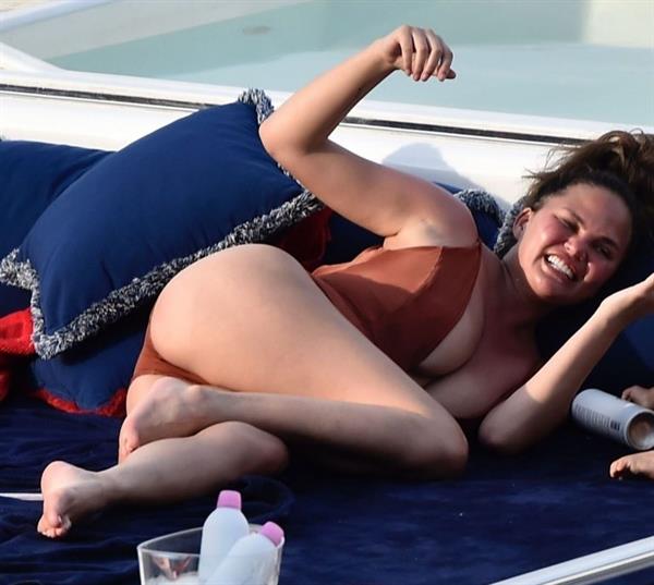 Chrissy Teigen sexy cleavage and ass in a swimsuit with her husband John Legend seen by paparazzi.
