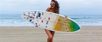 Shay Mitchell at the beach with a surfboard