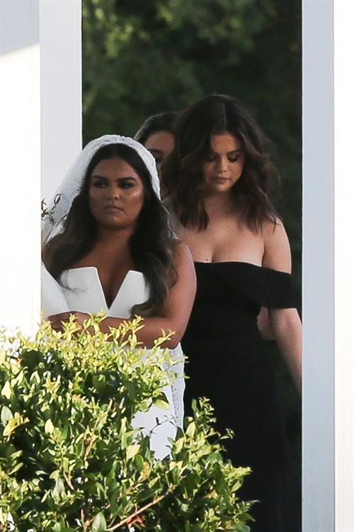 Selena Gomez Pictures Selena Gomez sexy in a black dress for her cousins wedding showing nice cleavage seen by paparazzi.