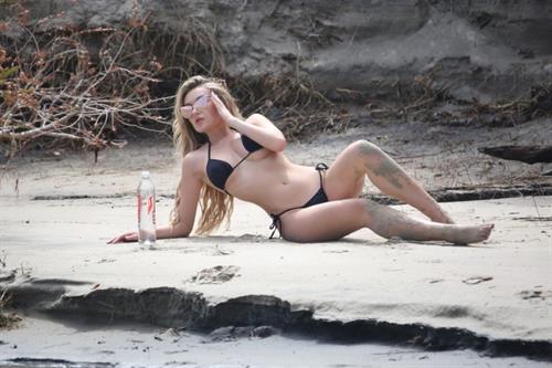 Trista Mikail Bikini Pictures Trista Mikail sexy thong bikini photo shoot showing nice cleavage and ass on the beach.