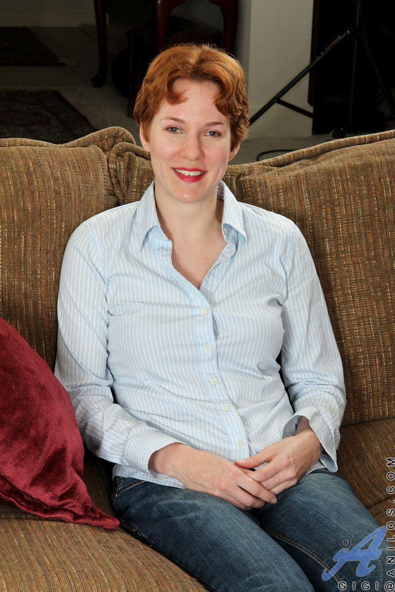 Gigi reads erotic literature and fingers her mature pussy as it moistens 