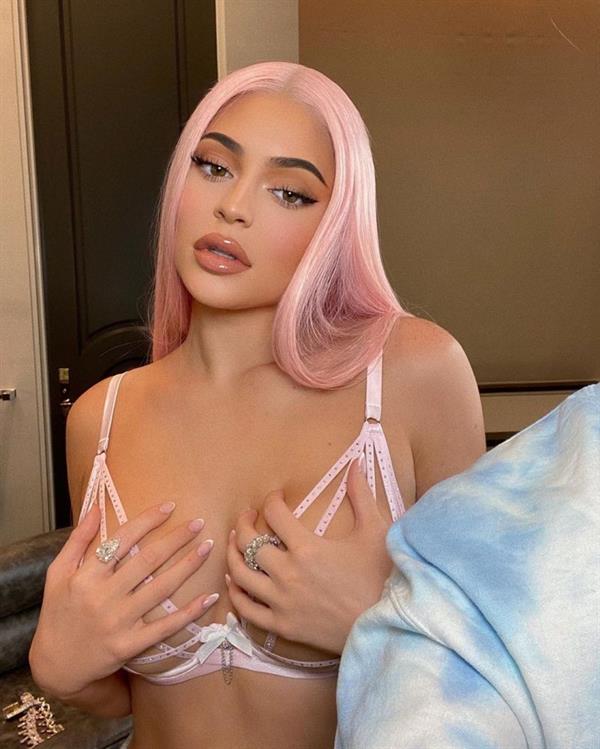 Kylie Jenner boobs in a see through sexy pink lingerie bra holding her big tits with hands showing off her pink hair.
