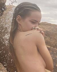 Dove Cameron nude boobs new photos wet outside covering her topless big tits also showing her sexy ass.