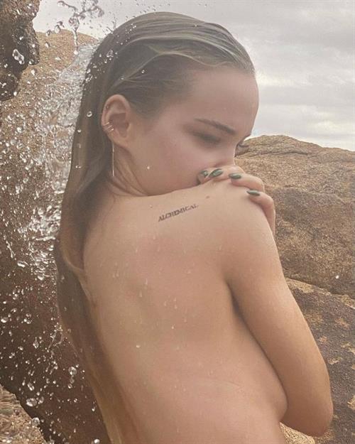 Dove Cameron nude boobs new photos wet outside covering her topless big tits also showing her sexy ass.